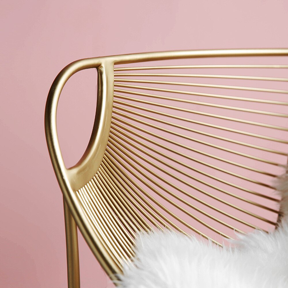 Chaise design en acier doré avec assise style hamac