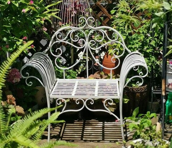 chaise vintage en fer forgé blanc dans un jardin